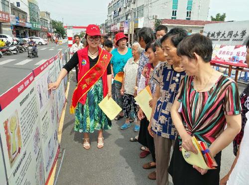 志愿者细心向群众解说图文并茂的反邪教宣传图版 志愿者细心向群众解说图文并茂的反邪教宣传图版