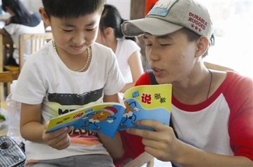 小学生和反邪教志愿者手捧《反邪教知识宣传手册》 小学生和反邪教志愿者手捧《反邪教知识宣传手册》