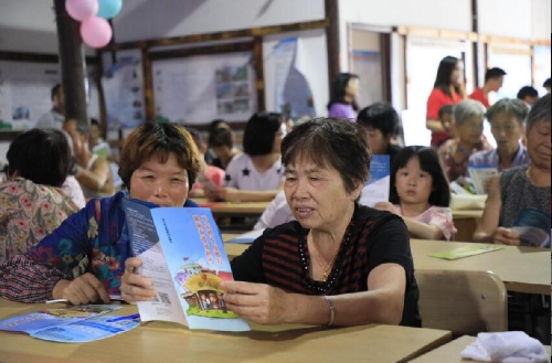 图 4分发反邪教宣传册,村民阅读反邪教宣传册 图 4分发反邪教宣传册,村民阅读反邪教宣传册