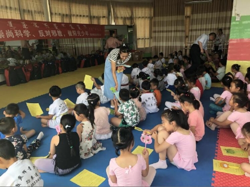 工作人员发放反邪教宣传物品和宣传册