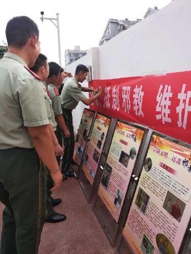 消防战士在反邪教宣传横幅上签字