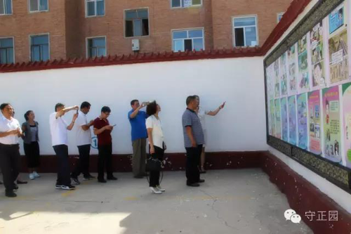 与会人员参观第四中学反邪教漫画墙