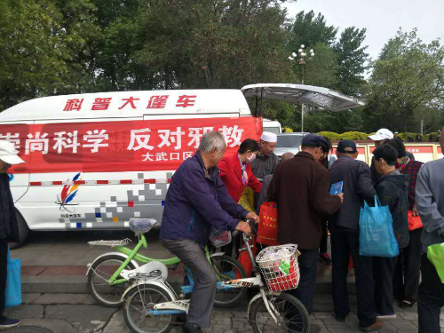 图片002:反邪教志愿者为现场各族群众发放反邪教宣传材料及购物袋 图片002:反邪教志愿者为现场各族群众发放反邪教宣传材料及购物袋