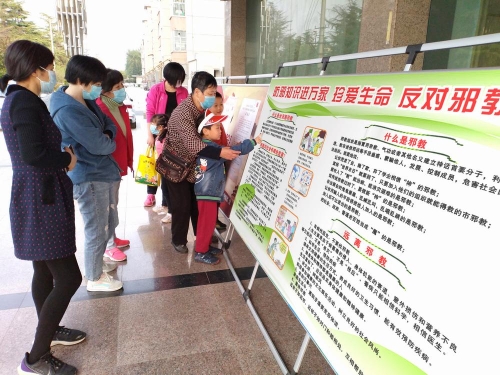 05钻采社区玉兰服务区员工为居民讲解反邪教宣传栏展版内容 05钻采社区玉兰服务区员工为居民讲解反邪教宣传栏展版内容