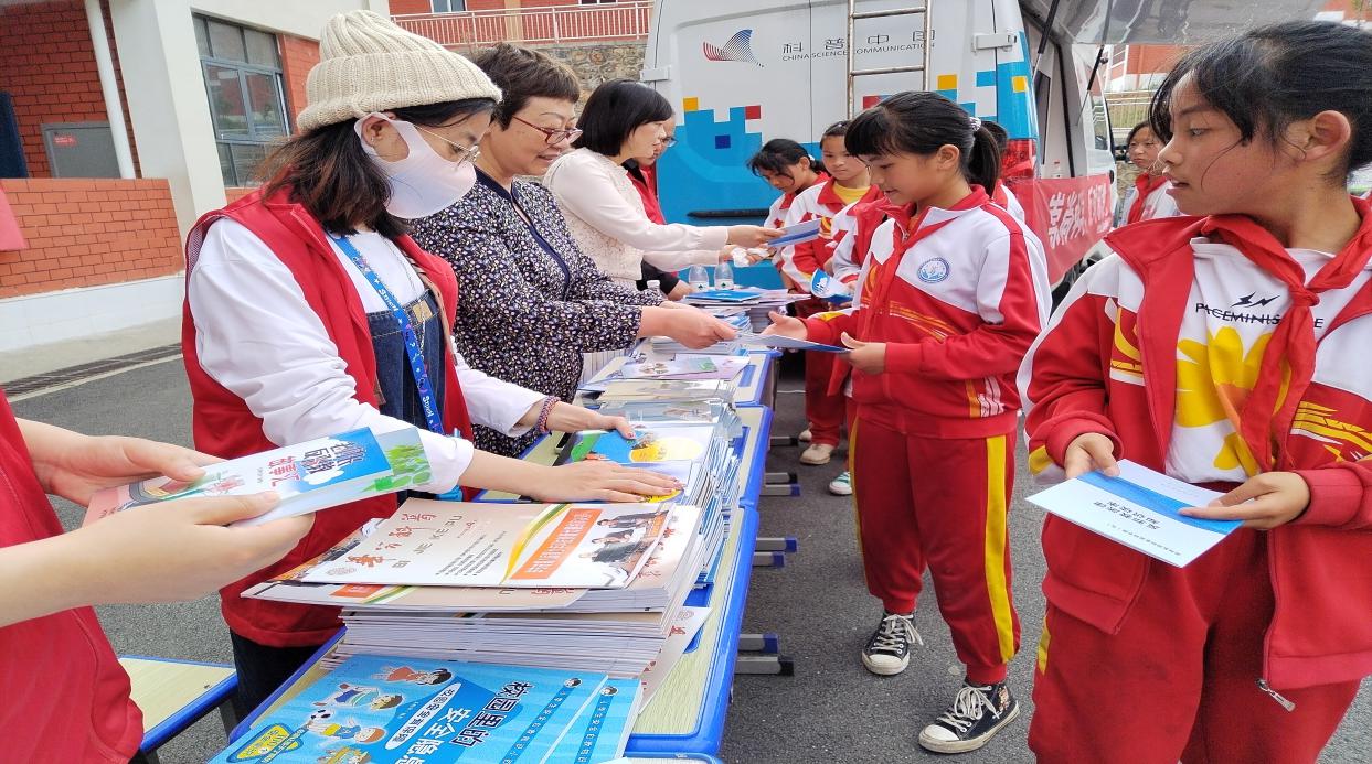 4.前所小学-科普志愿者向学生发放科普宣传资料.jpg