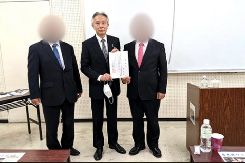 ▲2021年10月17日，盛山正仁（中）在“国际胜共联合”主办的一场政策说明会上持有“国际胜共联合”的推荐信。图源：朝日新闻.jpg