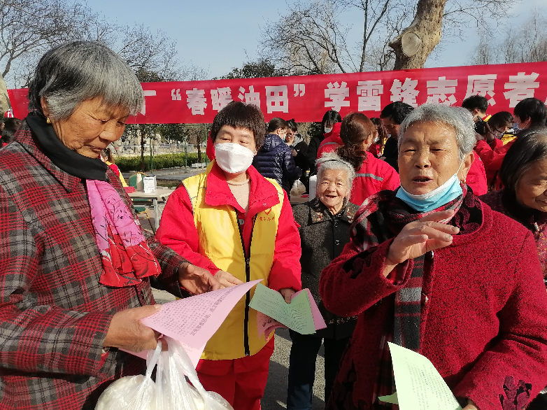 图3：向社区居民发放反邪教宣传册.png