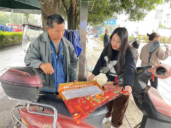 图：工作人员向群众科普反邪教知识并赠送反邪教“挂历”.jpg