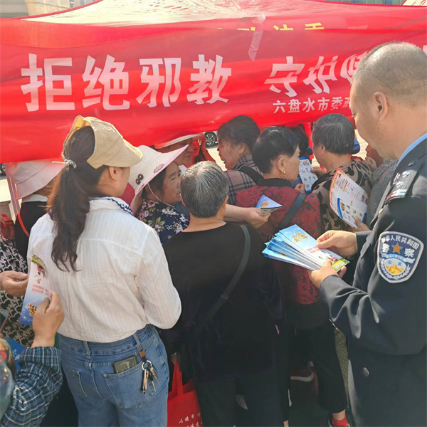 （图为：宣传人员向群众边发放宣传资料边讲解邪教相关知识）_副本.jpg